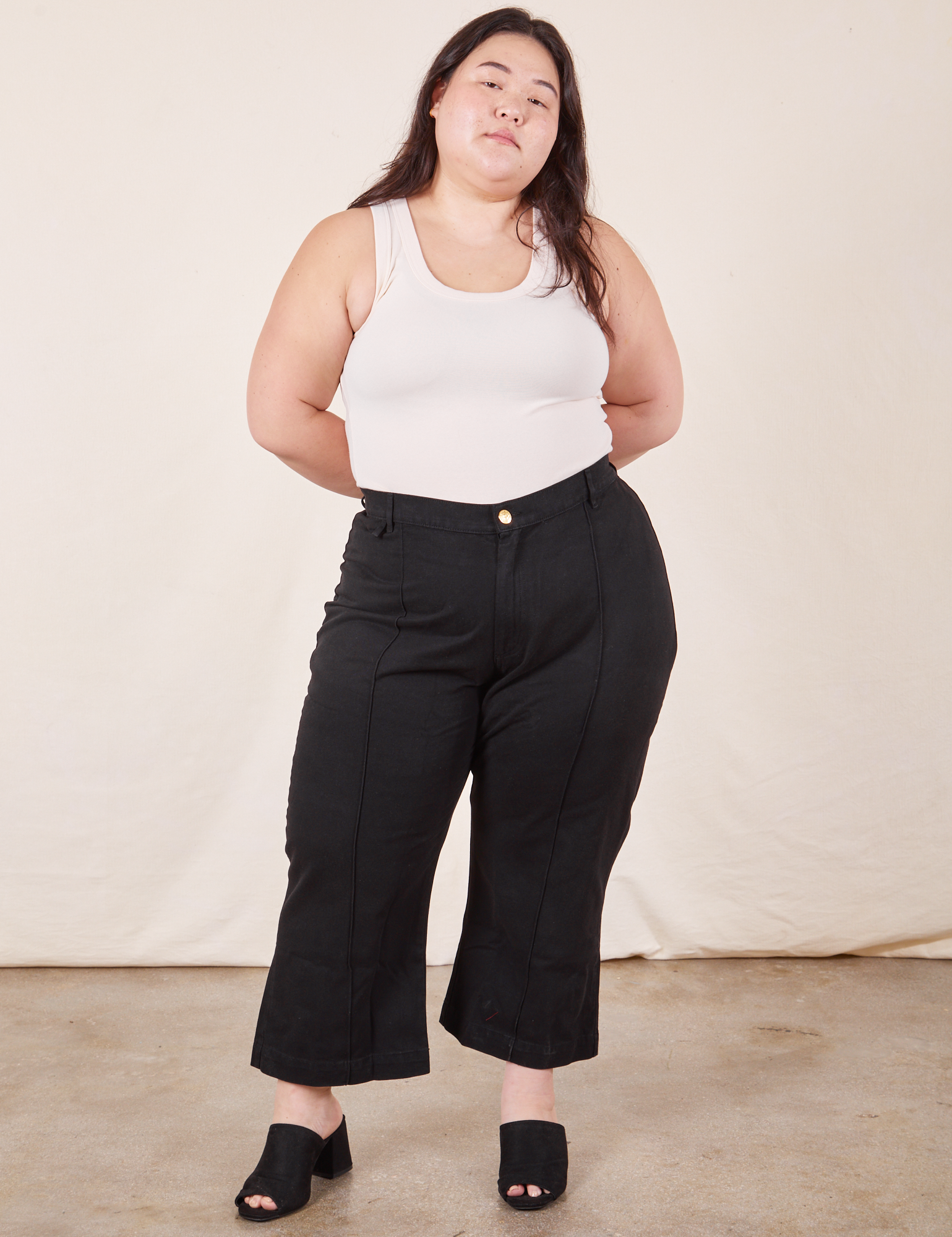 Ashley is 5&#39;7 and wearing 1XL Petite Western Pants in Basic Black paired with Tank Top in vintage tee off-white