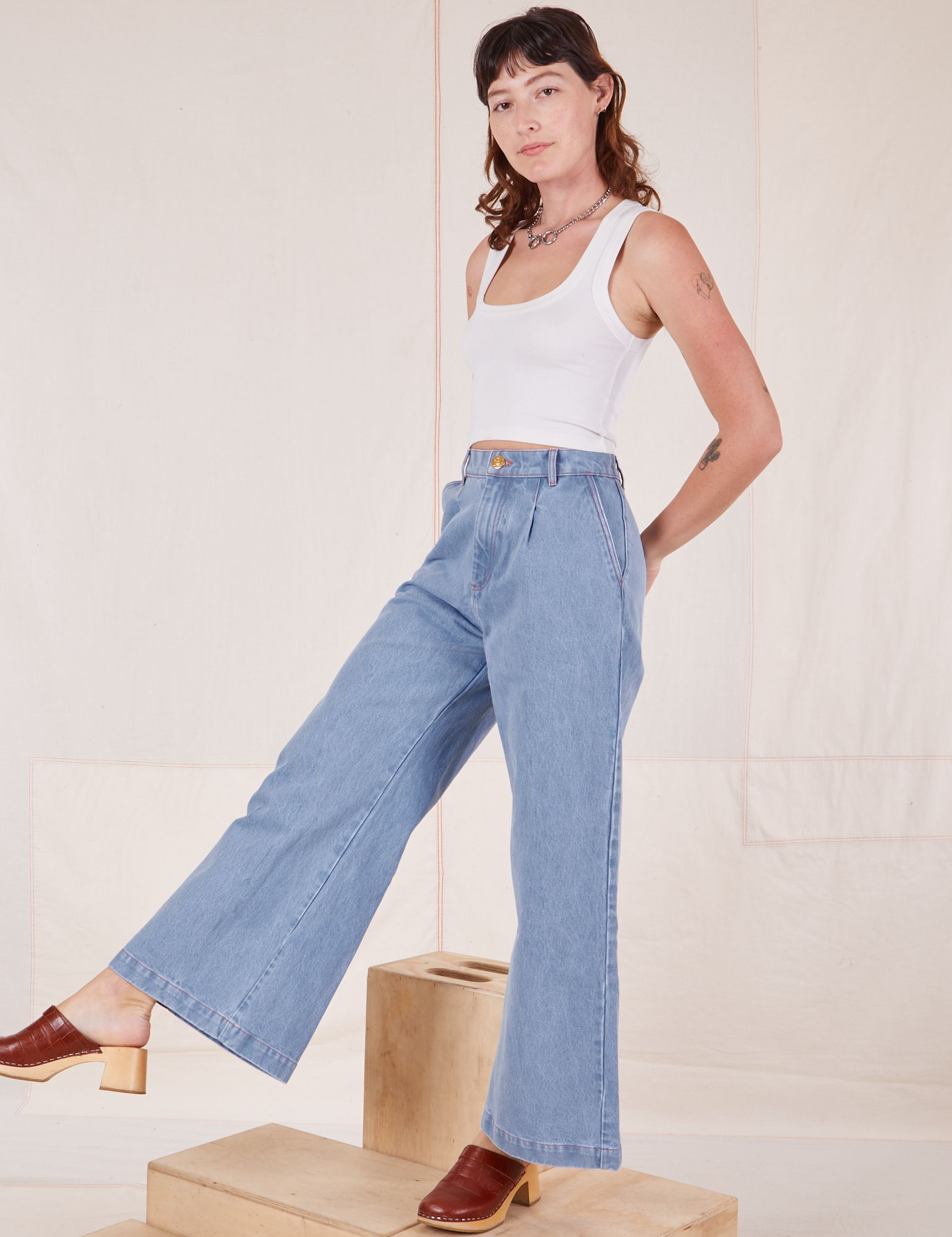 Alex is 5&#39;8&quot; and wearing XXS Indigo Wide Leg Trousers in Light Wash paired with Cropped Tank Top in Vintage Off-White