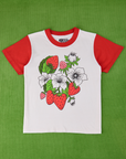 Anniversary Tee in Strawbaby. White t-shirt body with mustang red sleeves and neckline. Graphic strawberries on the front of the tee.