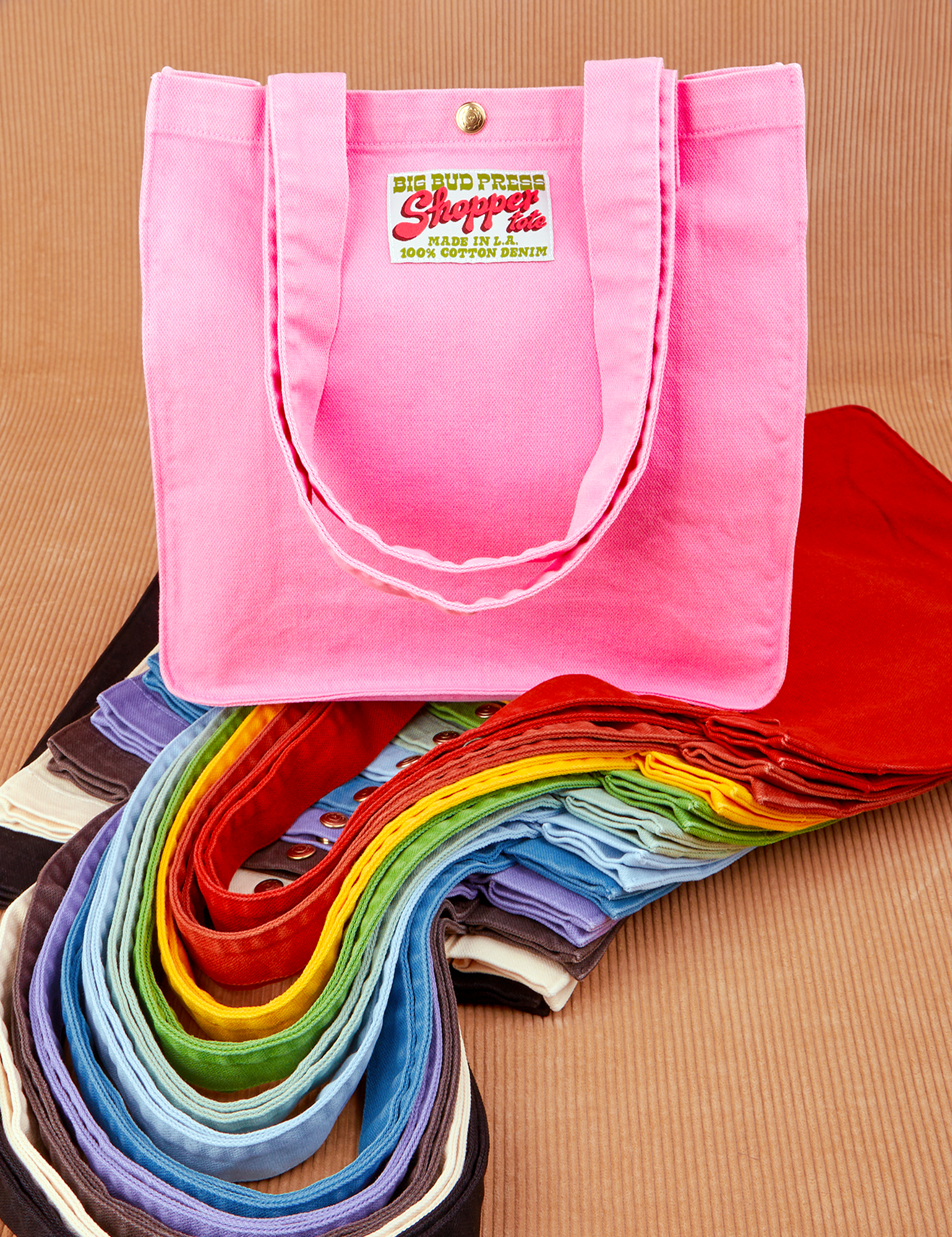 Shopper Tote Bag in a rainbow of hues. Bubblegum pink colorway on top of stack of all other colors.