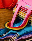 A rainbow of stacked Over-Shoulder Zip Mini Tote