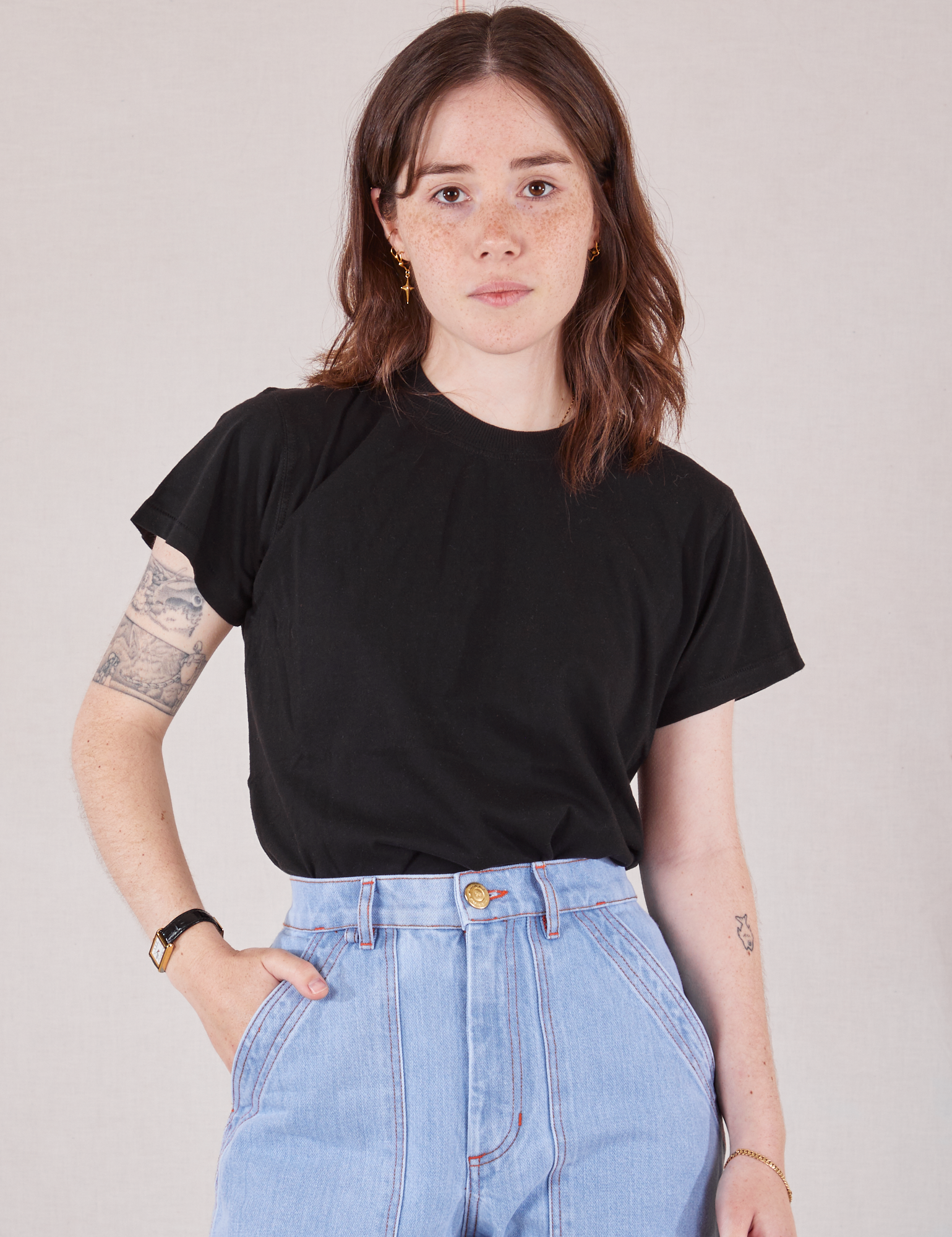 Hana is 5&#39;3&quot; and wearing P Organic Vintage Tee in Basic Black tucked into light wash Carpenter Jeans