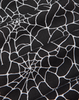 Work Pants in Spiderwebs fabric detail close up. Black fabric with white printed spiderwebs.