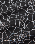 Drop Pocket Cargo Pants in Spider Webs detail close up. Black fabric with white printed spiderwebs