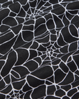Cropped Tank Top in Spider Webs detail close up. Black fabric with white printed spiderwebs