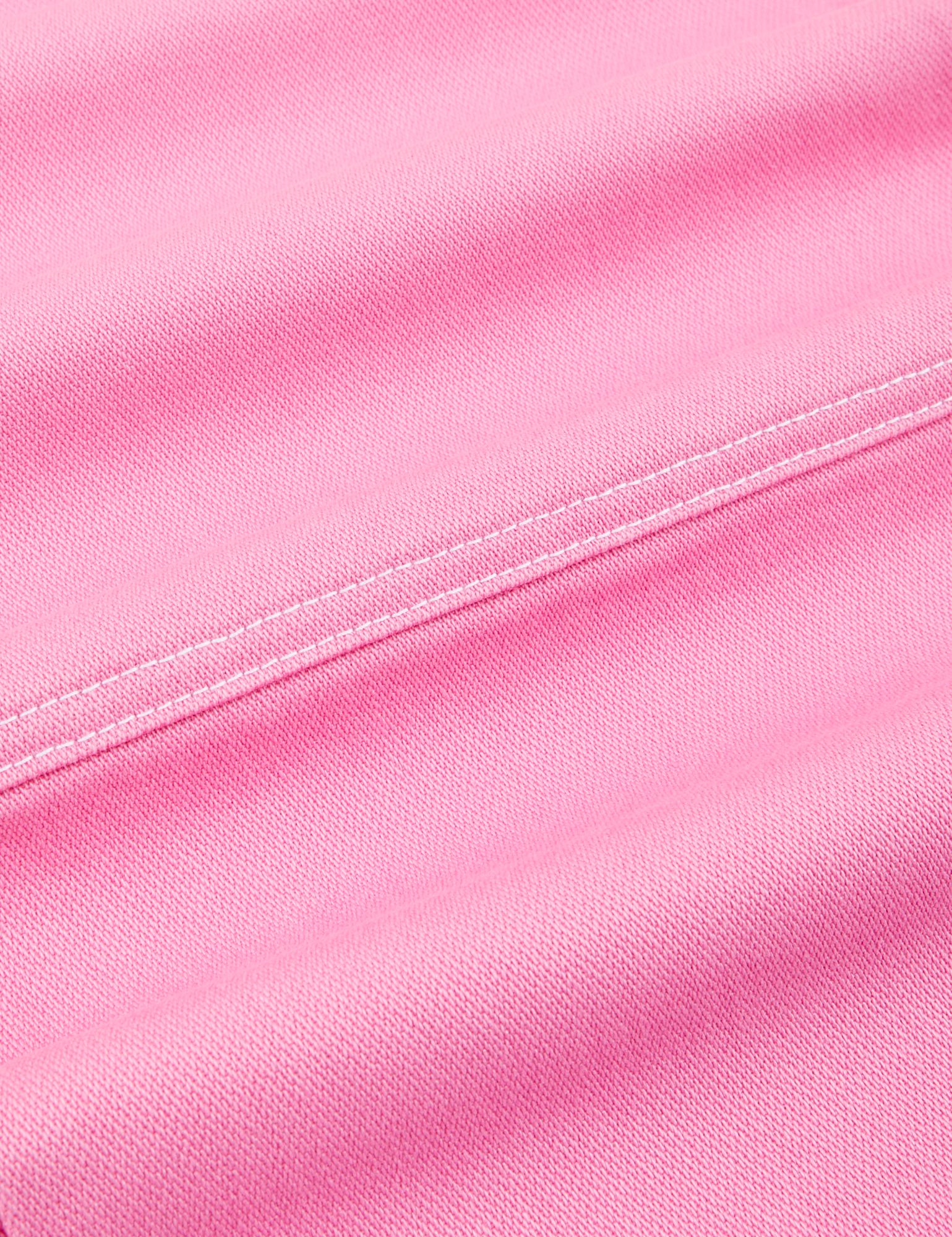 Carpenter Jeans in Bubblegum Pink fabric detail close up with contrast white top stitching.