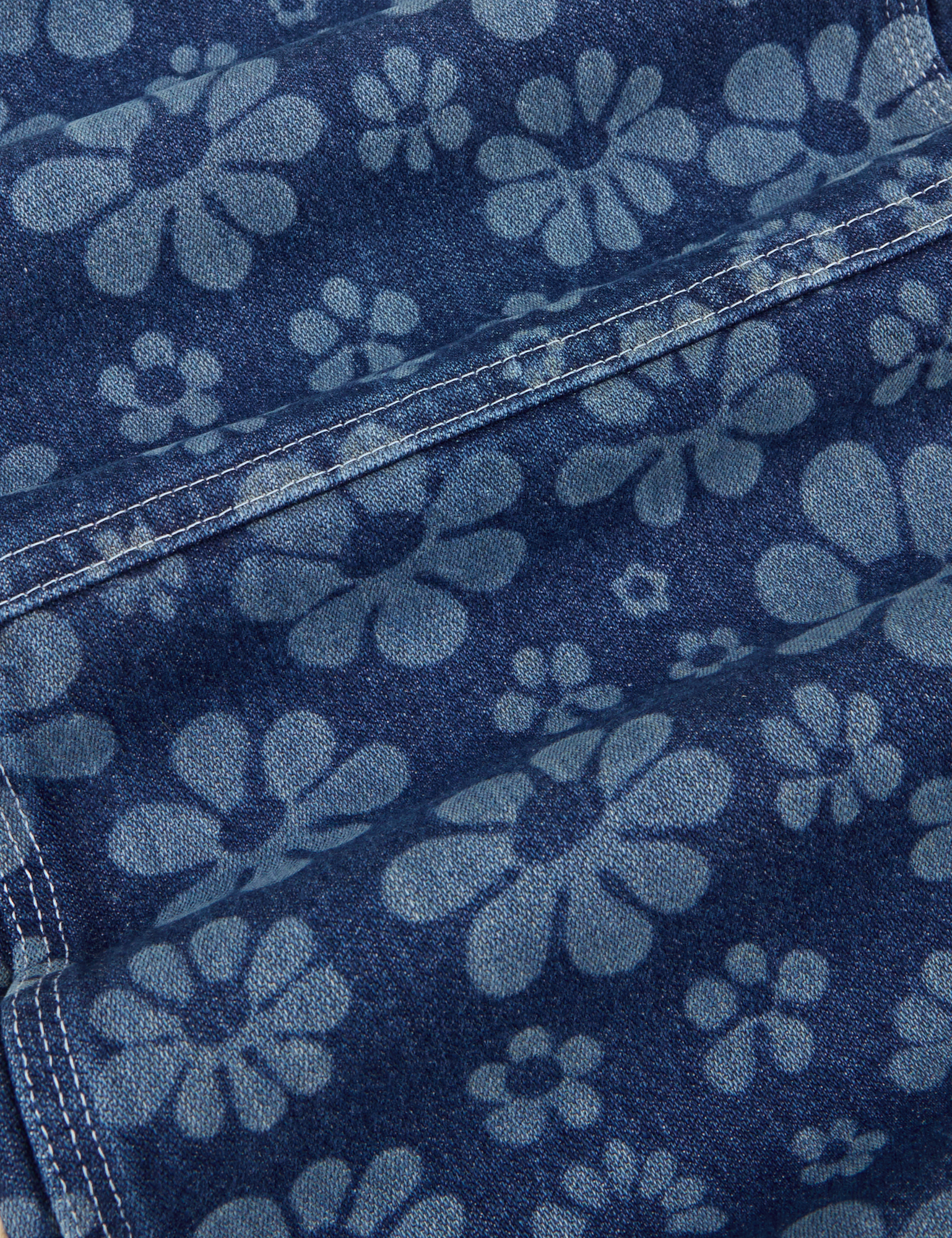 Carpenter Overalls in Lazy Daisy fabric detail close up. Laser etched daisies on denim fabric.