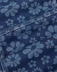 Carpenter Overalls in Lazy Daisy fabric detail close up. Laser etched daisies on denim fabric.