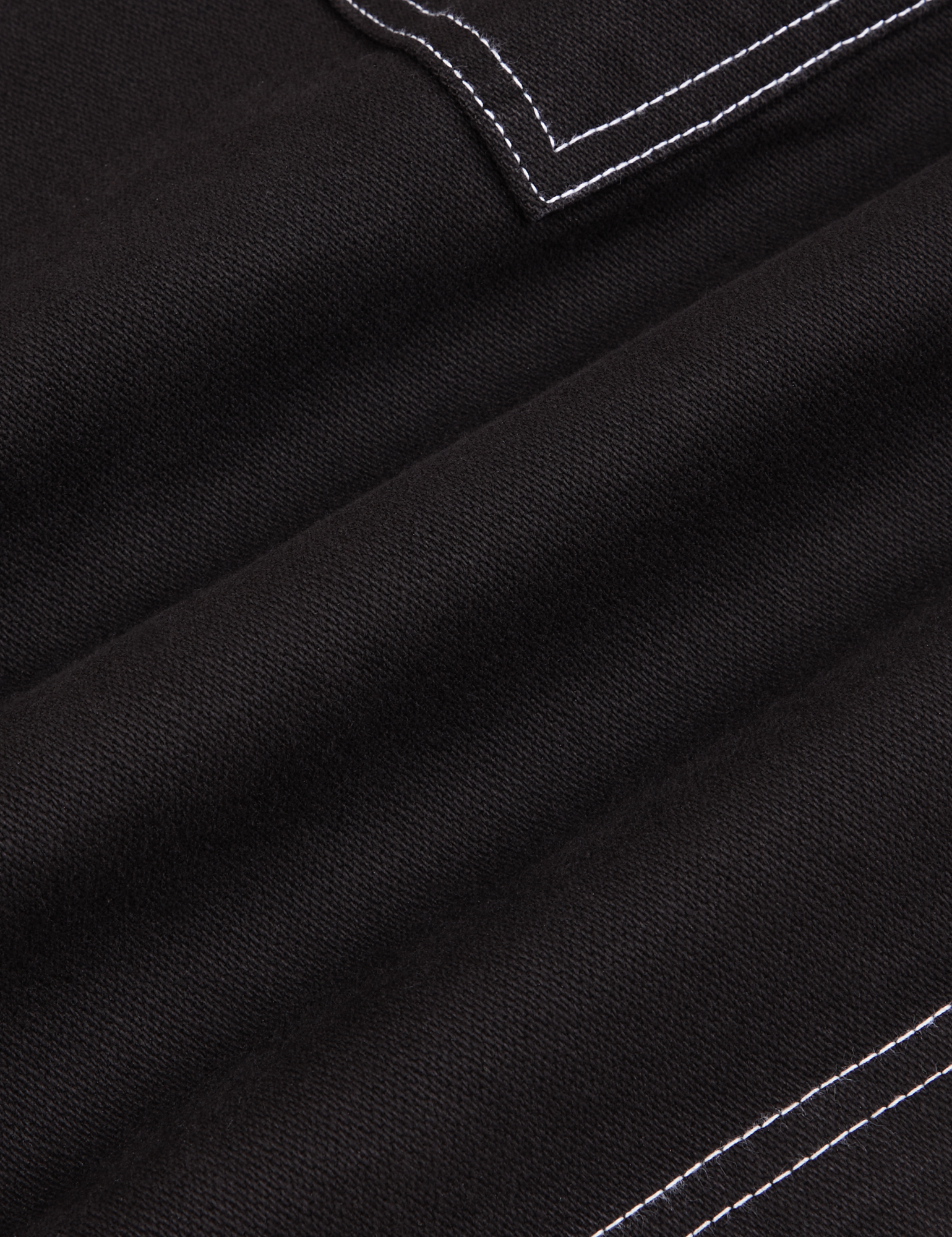 Carpenter Shorts in Basic Black fabric detail close up.Contrast white stitching.