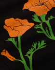 Paintstamped Work Pants in Poppy fabric detail close up. Orange poppy with green stems and leaves.