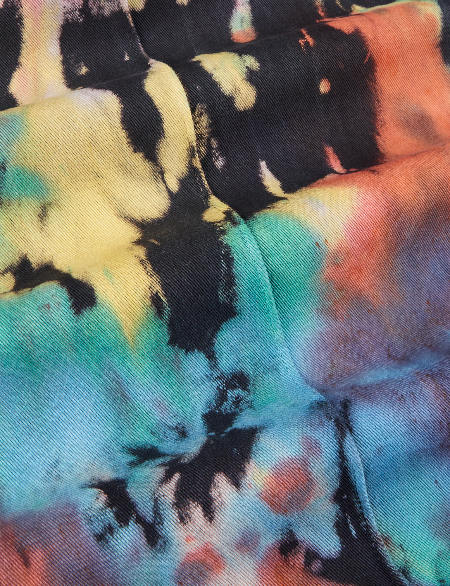 Western Pants in Rainbow Magic Waters fabric detail close up. Tie dye in blues, greens, reds, yellows and oranges