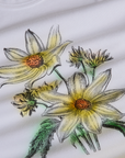 Close up of screen print flowers on Floral Long Sleeve Baby Tee in Yellow