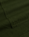 Close-up of dark green fabric with a visible seam