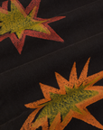 Paintstamped Work Pants in Explosion close up of paint stamped explosion shapes in orange, red and yellow.
