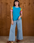 Alex is wearing P Calypso Tee in Rainbow paired with light wash Wide Leg Trouser Jeans