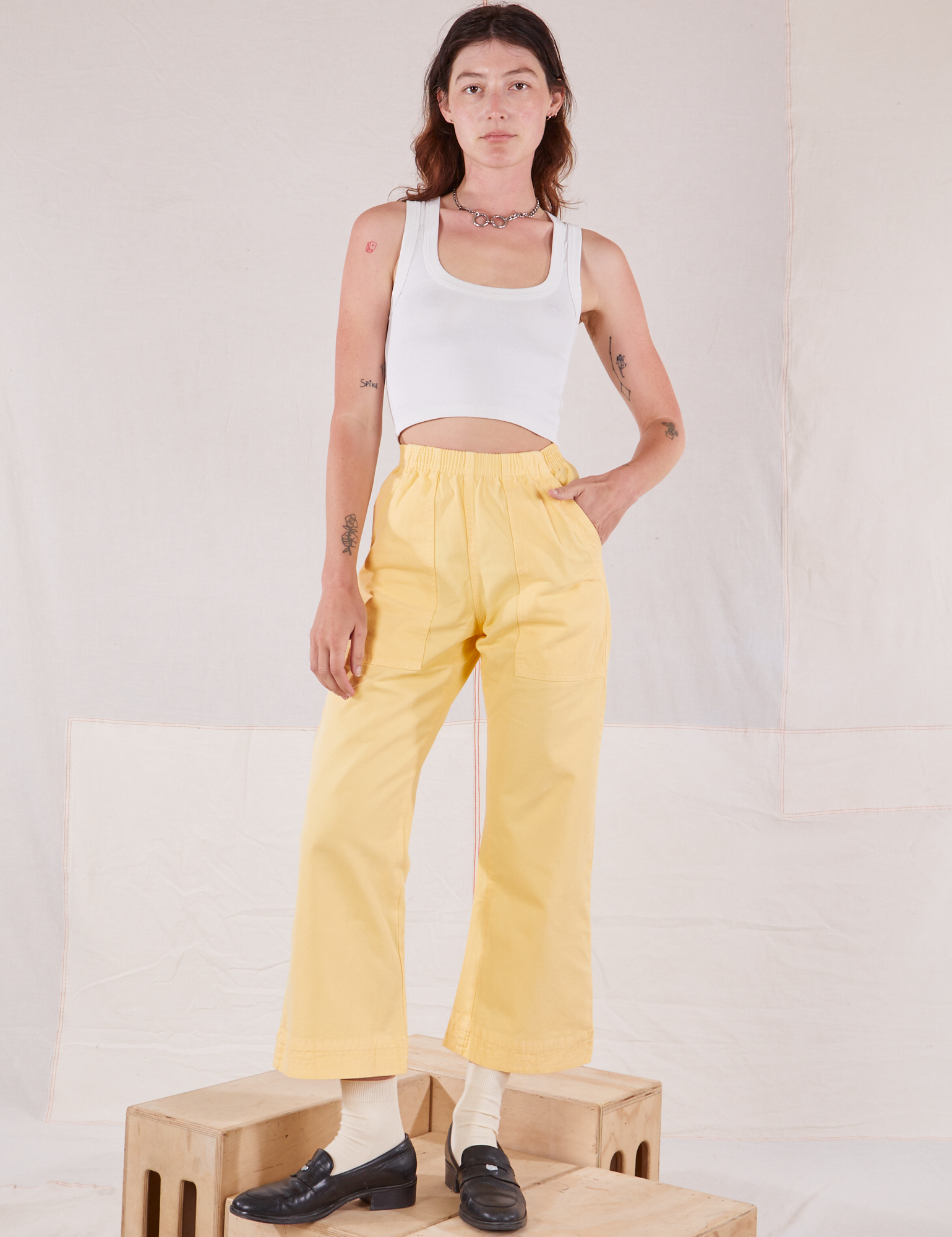 Alex is 5'8" and wearing P Action Pants in Butter Yellow paired with Cropped Tank in vintage tee off-white