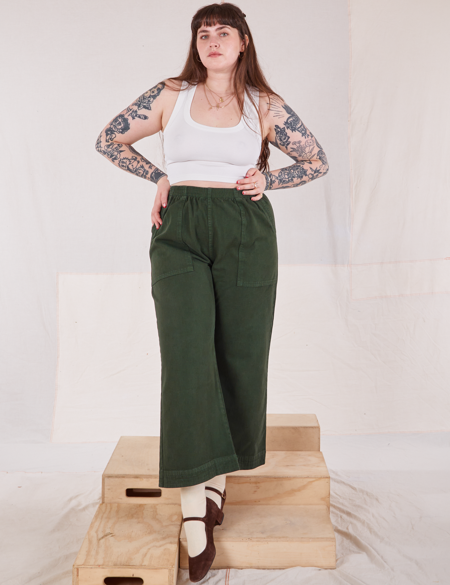 Sydney is 5'9" and wearing L Action Pants in Swamp Green paired with Cropped Tank in vintage tee off-white