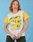 Tiara is 5’4” and wearing XS Anniversary Tee in Lemon