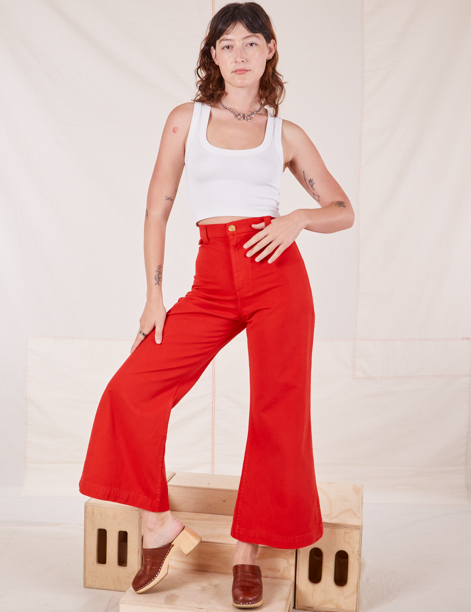 Alex is 5'8" and wearing XXS Bell Bottoms in Mustang Red paired with vintage off-white Cropped Tank Top