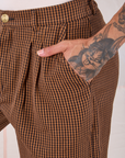 Close up of Jesse's hand in the front pocket of Checker Trousers in Brown & Black