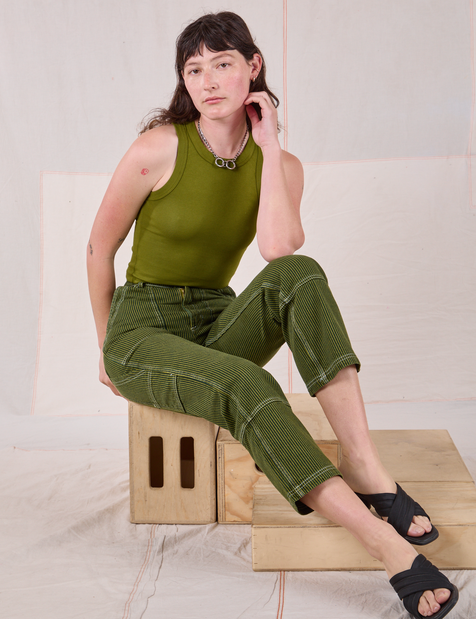 Alex is wearing Railroad Carpenter Jeans in Summer Olive and Muscle Tee in Summer Olive
