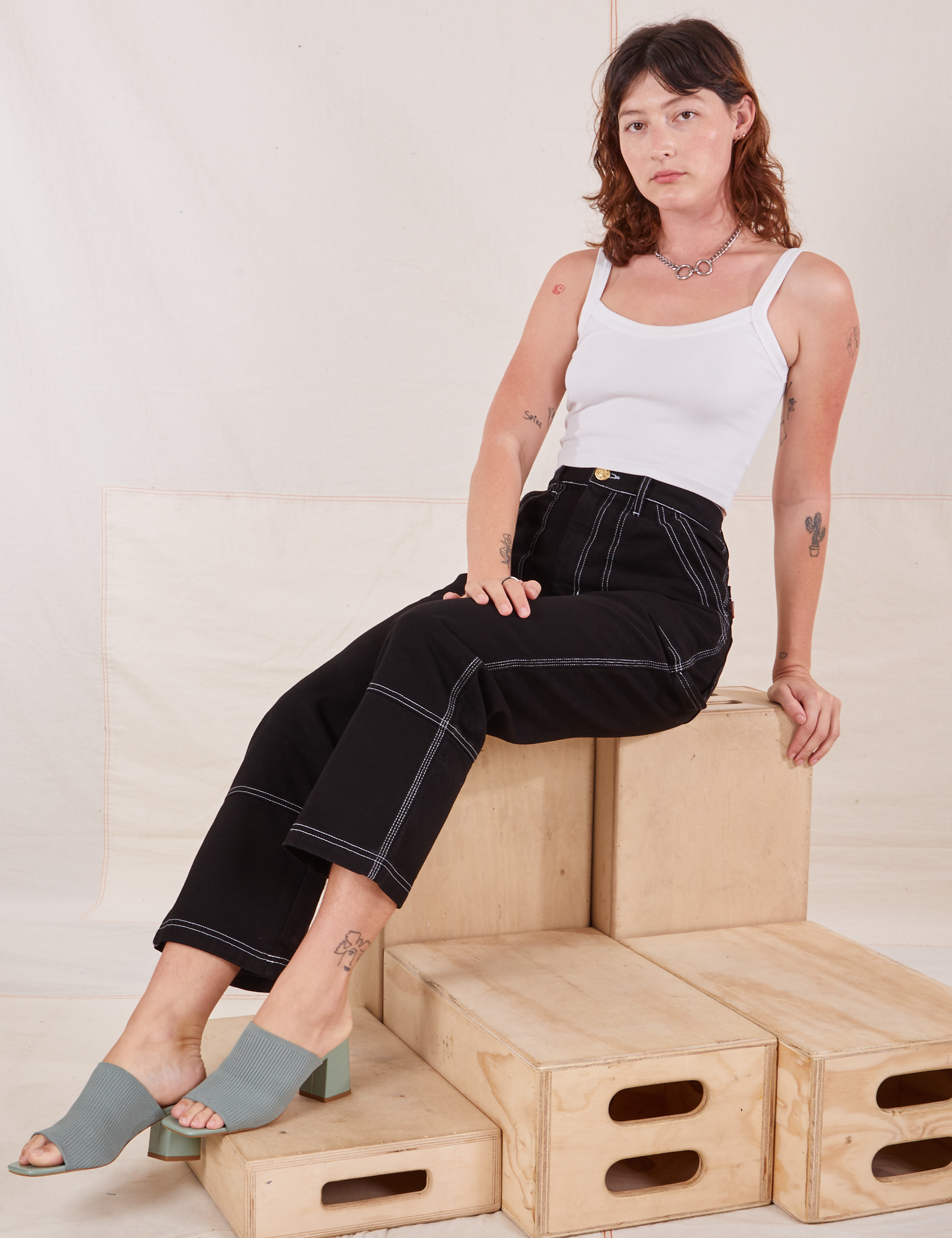 Alex is wearing Carpenter Jeans in Black and Cropped Cami in vintage tee off-white