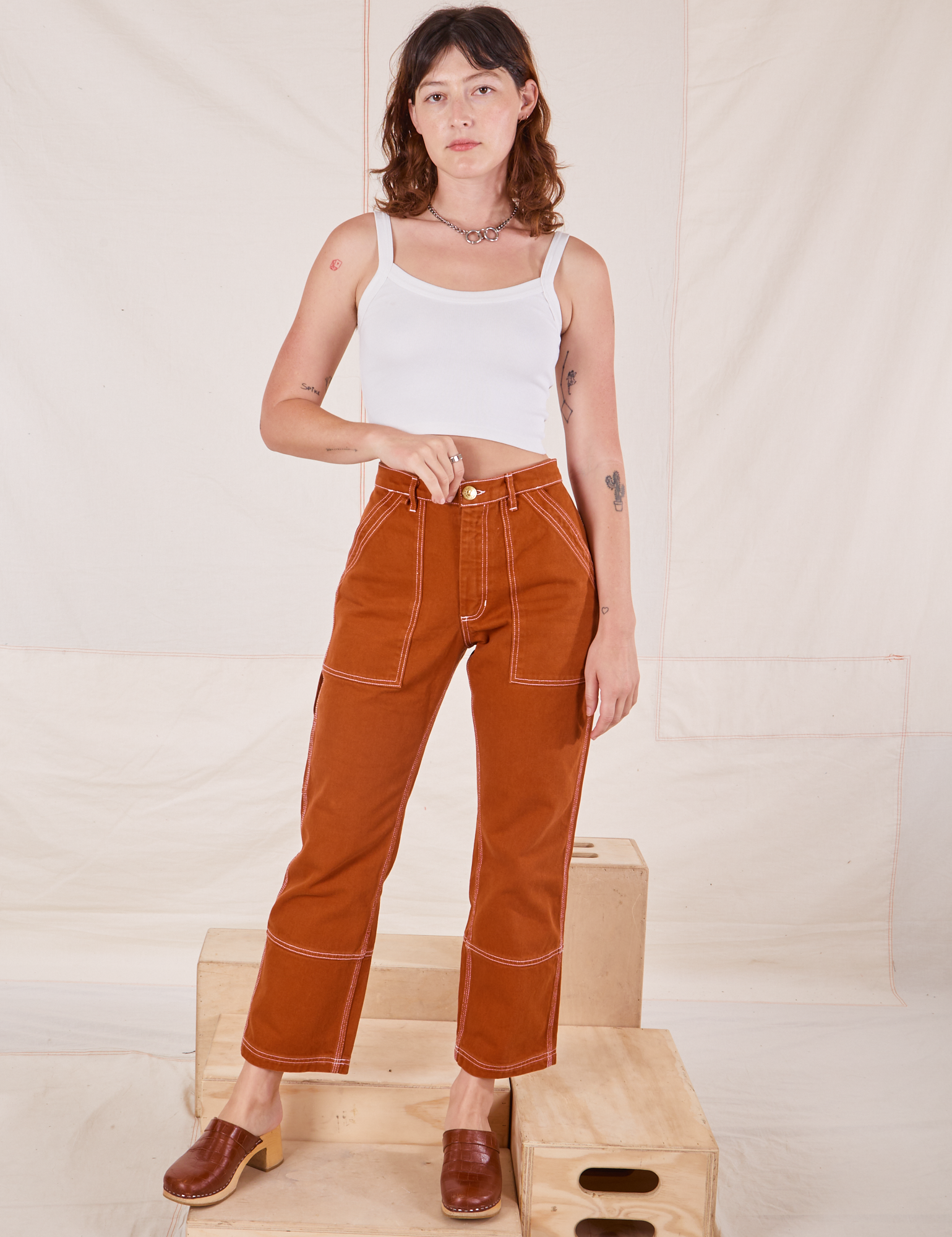 Alex is 5&#39;8&quot; and wearing XXS Carpenter Jeans in Burnt Terracotta paired with Cropped Cami in vintage tee off-white