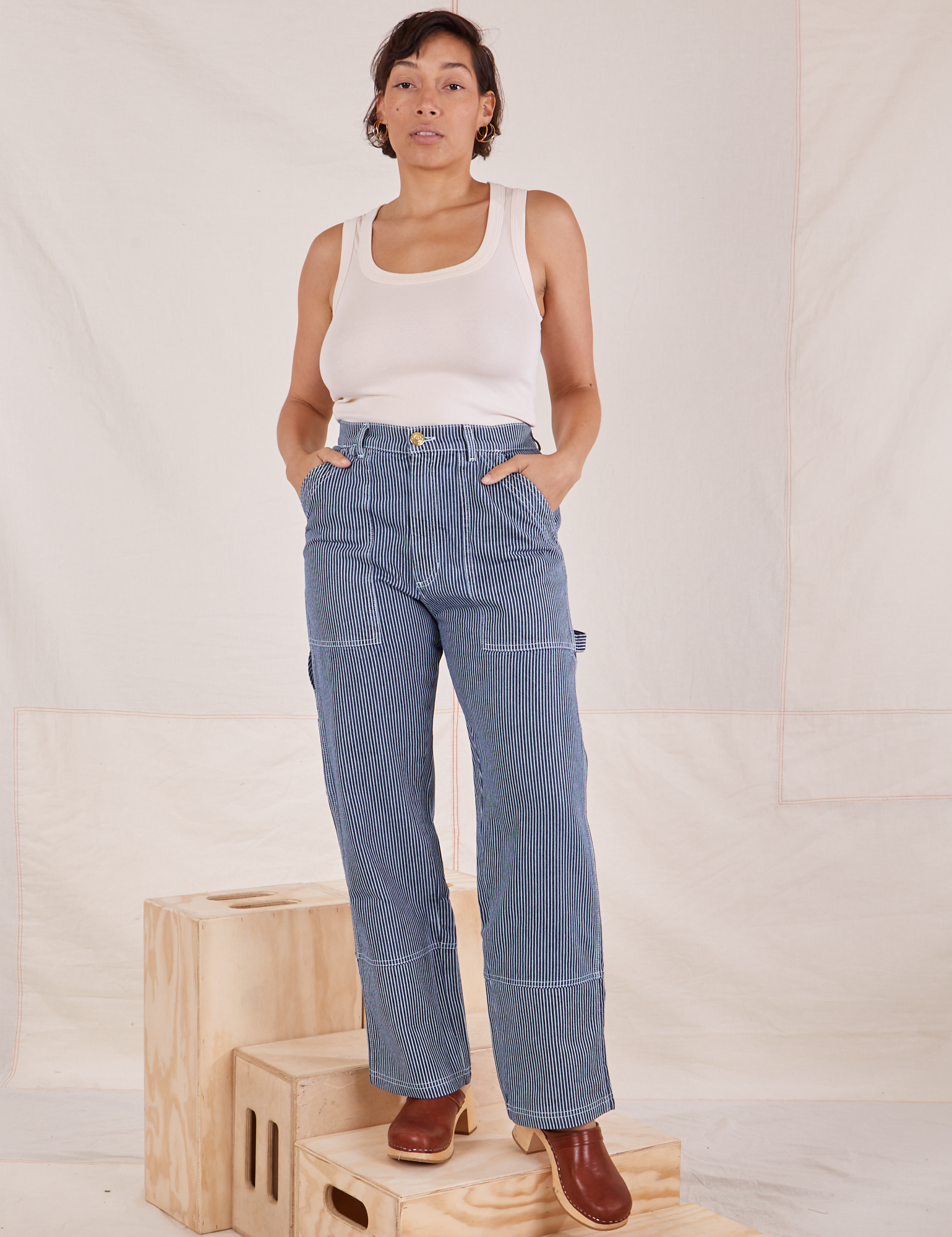 Tiara is 5&#39;4&quot; and wearing S Carpenter Jeans in Railroad Stripes paired with a vintage off-white Tank Top