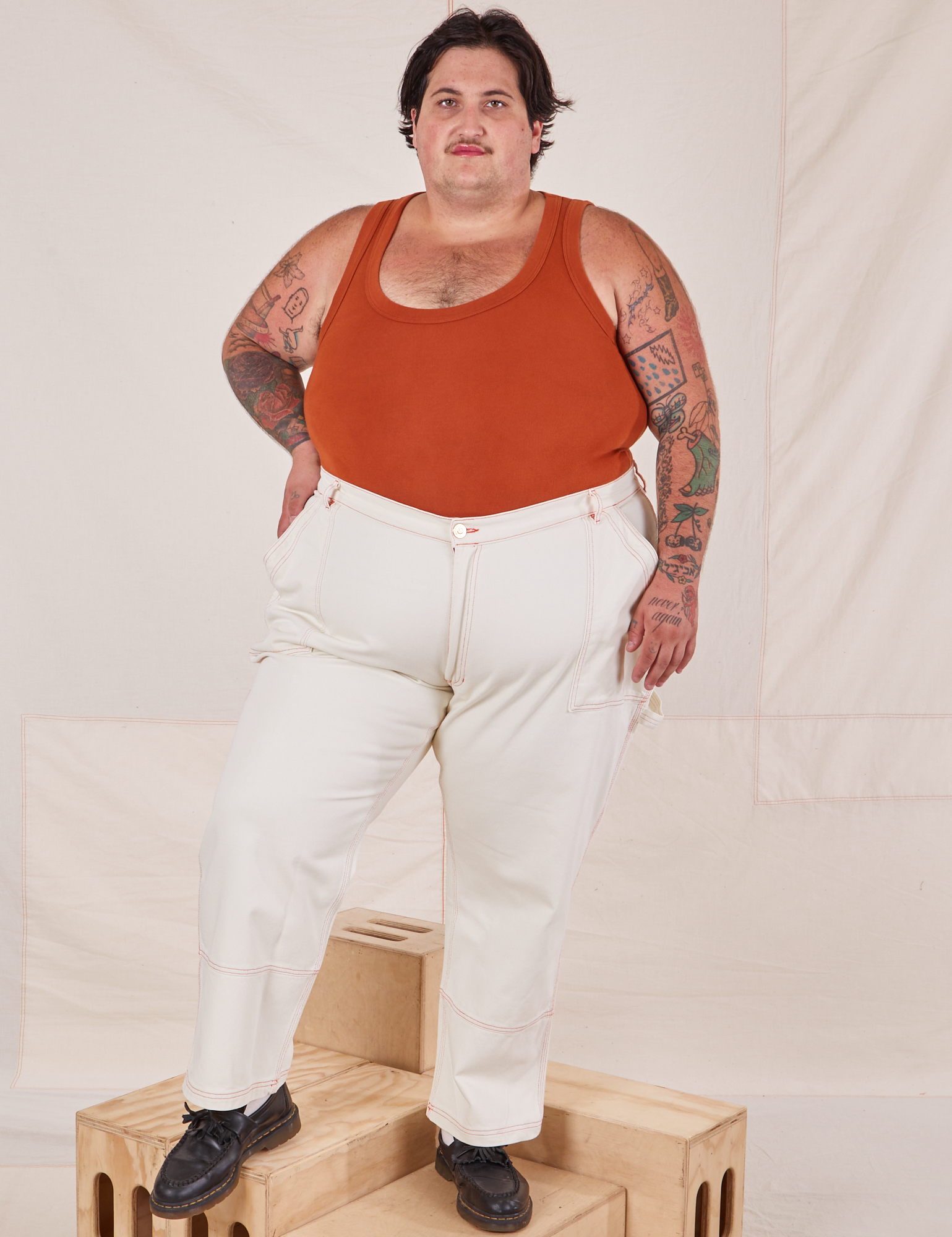 Sam is 5&#39;10&quot; and wearing 3XL Carpenter Jeans in Vintage Tee Off-White paired with burnt terracotta Cropped Tank Top