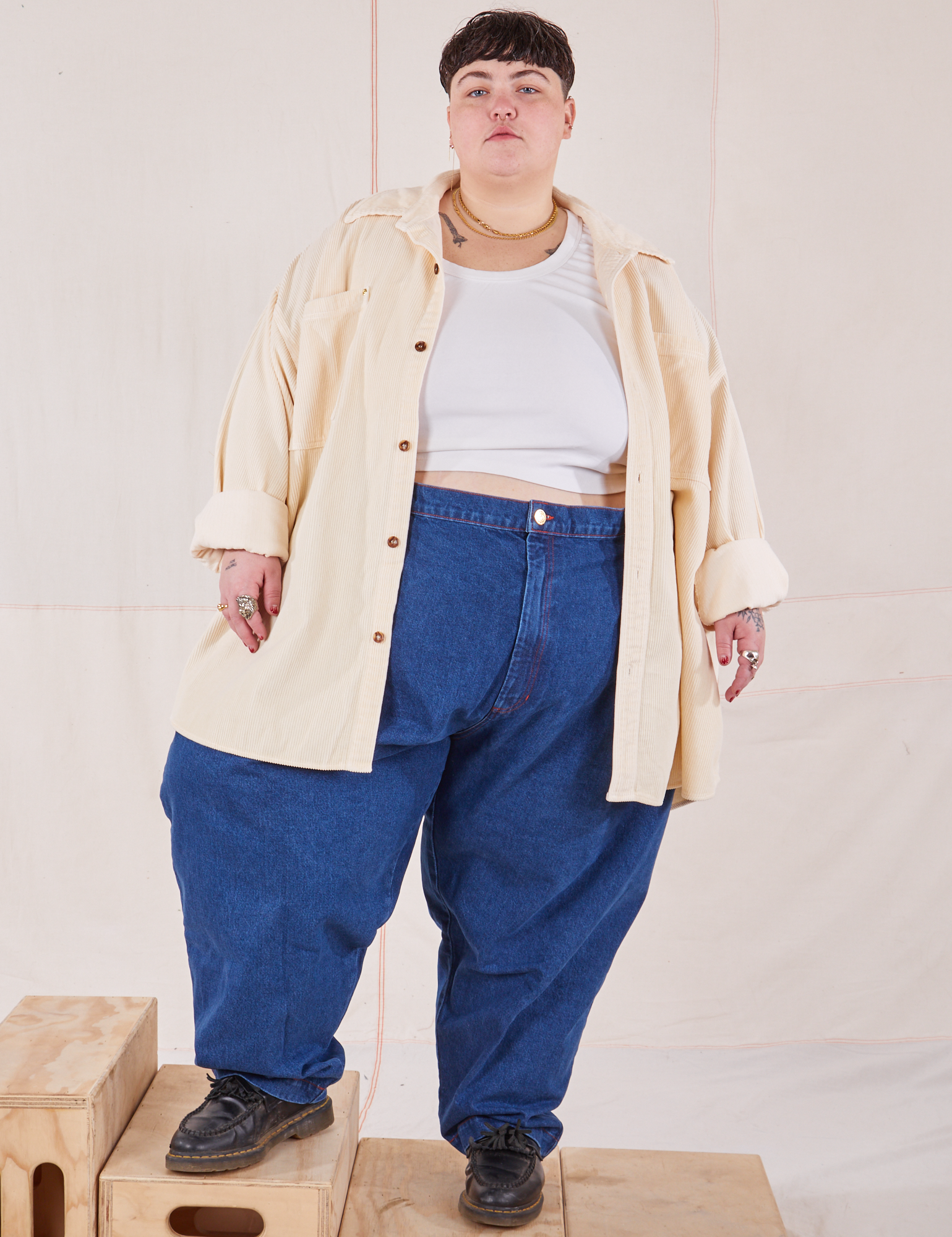 Jordan is wearing Corduroy Overshirt in Vintage Off-White with a vintage off-white Cropped Tank Top underneath and dark wash Denim Trouser Jeans