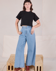 Alex is wearing Cropped Burly Tee in Basic Black and light wash Indigo Wide Leg Denim Trousers