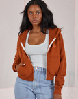 Kandia is 5'3" and wearing P Cropped Zip Hoodie in Burnt Terracotta paired with a vintage off-white Cropped Tank underneath