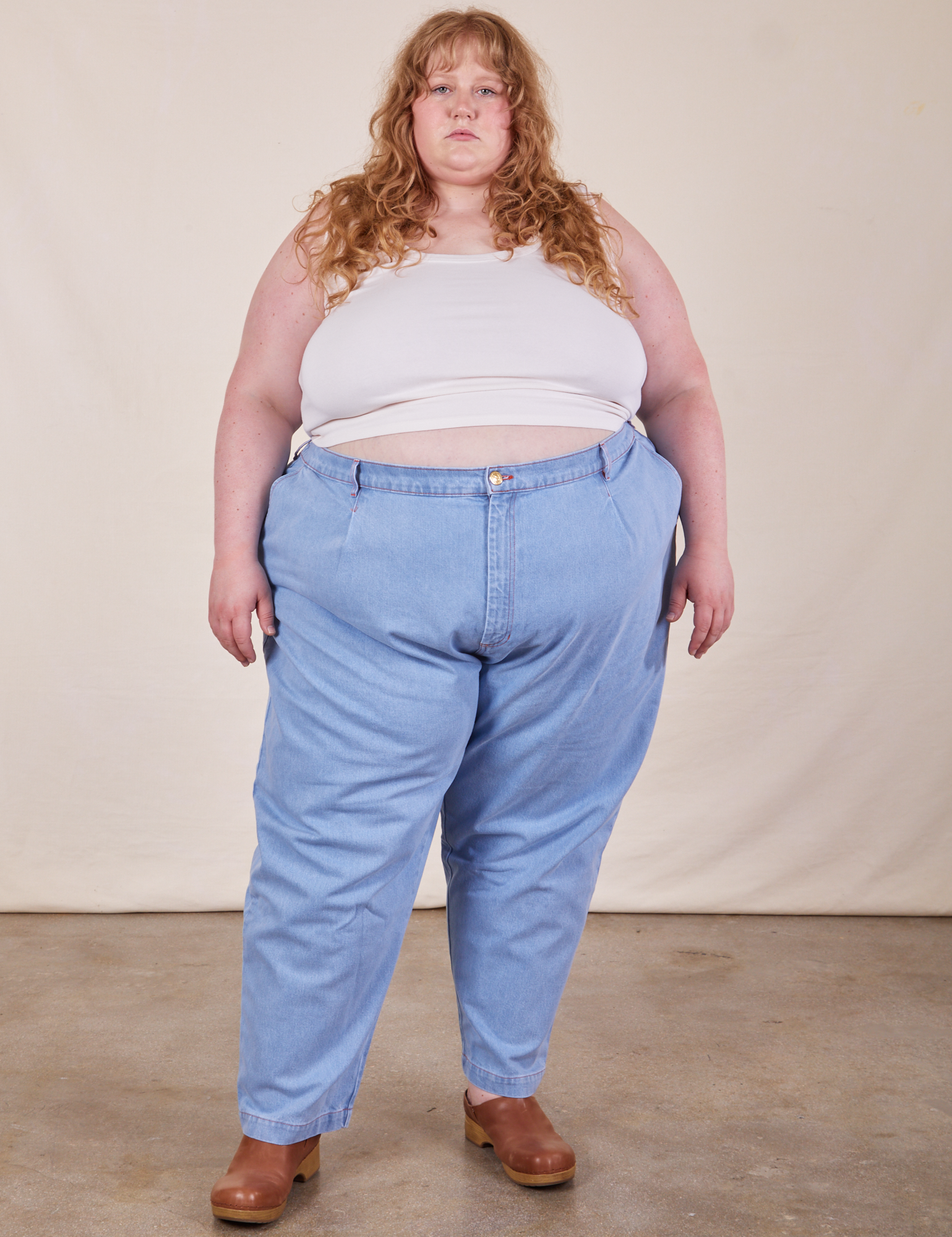 Catie is wearing Cropped Tank Top in Vintage Off-White and light wash Denim Trousers