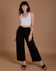 Alex is 5’8” and wearing XXS Drop Pocket Cargo Pants in Basic Black paired with a Cropped Tank in vintage tee white