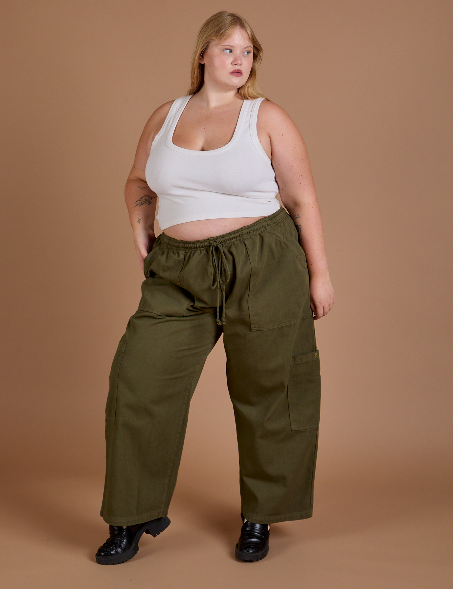 Juliet is 5’7” and wearing 1XL Drop Pocket Cargo Pants in Surplus Green paired with a Cropped Tank in vintage tee white