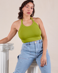 Tiara is wearing Halter Top in Gross Green paired with light wash Carpenter Jeans
