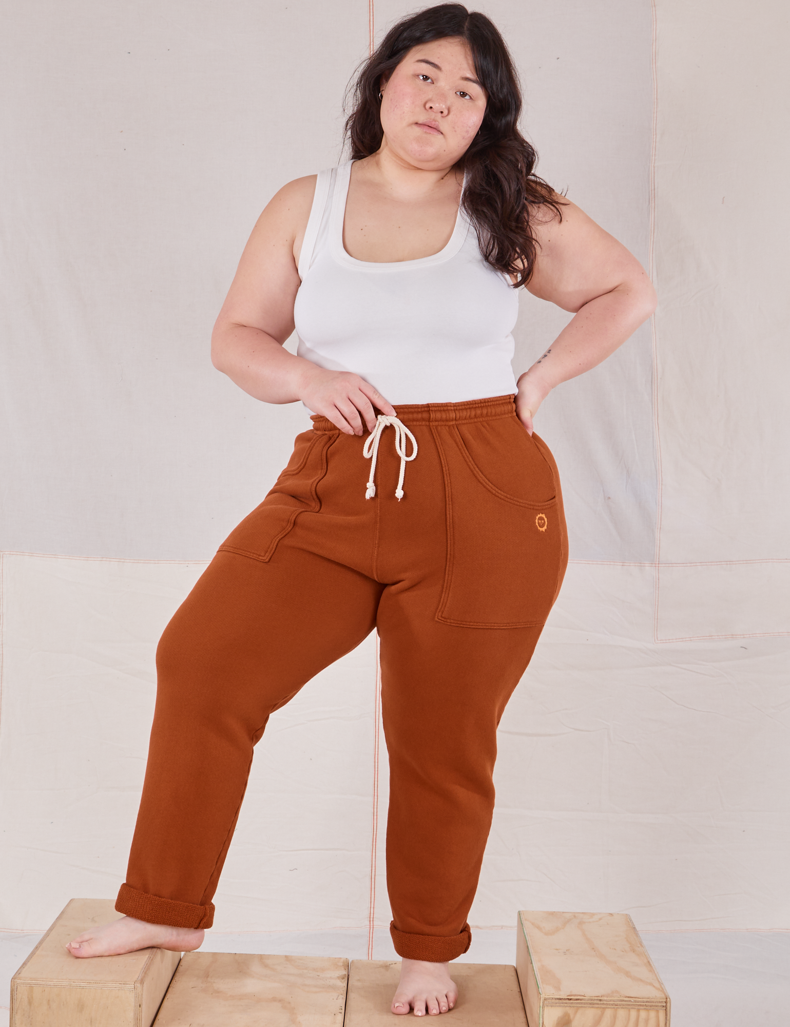 Ashley is 5&#39;7&quot; and wearing L Rolled Cuff Sweat Pants in Burnt Terracotta paired with Cropped Tank in vintage tee off-white 