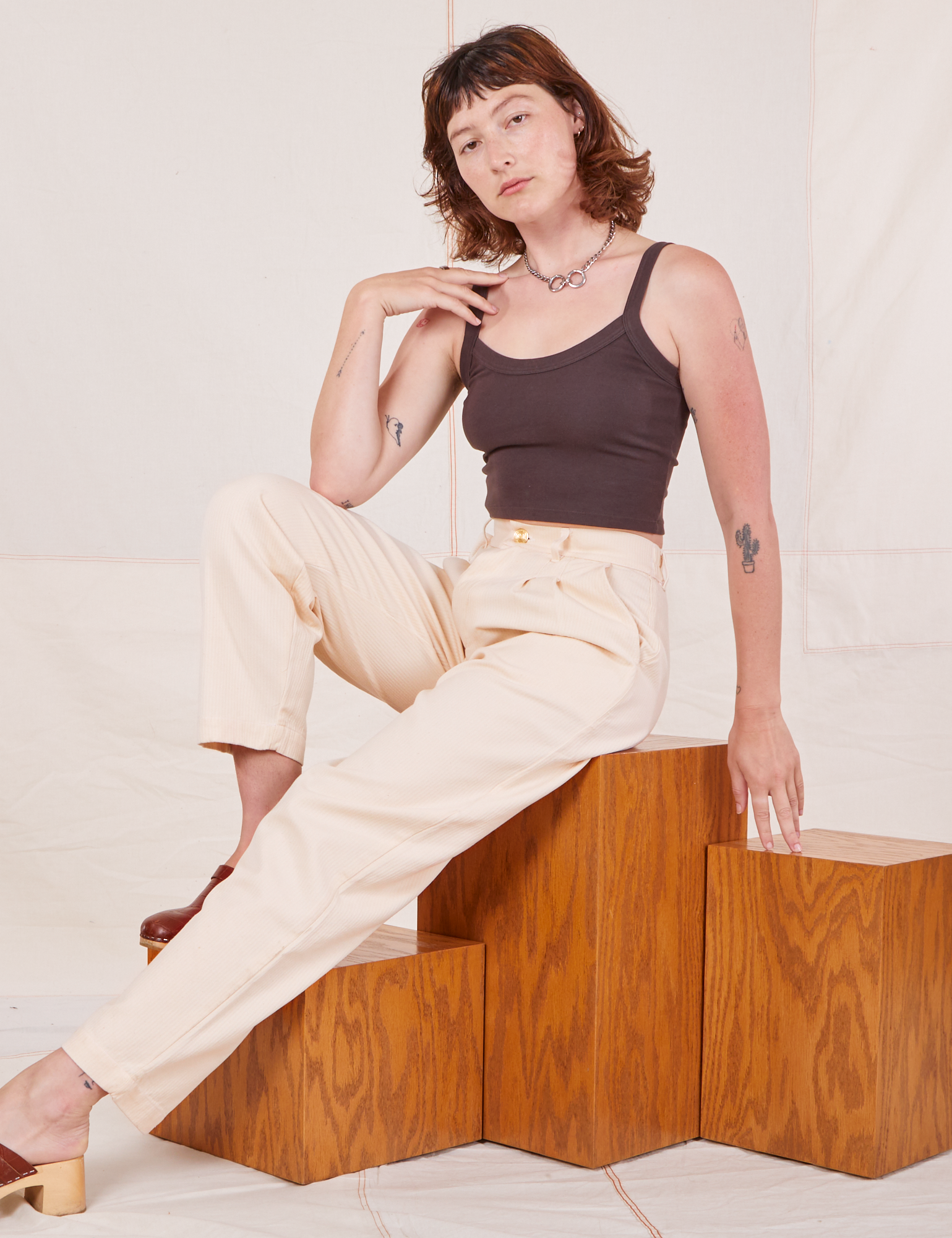Alex is wearing Heritage Trousers in Vintage Off-White and espresso brown Cropped Cami