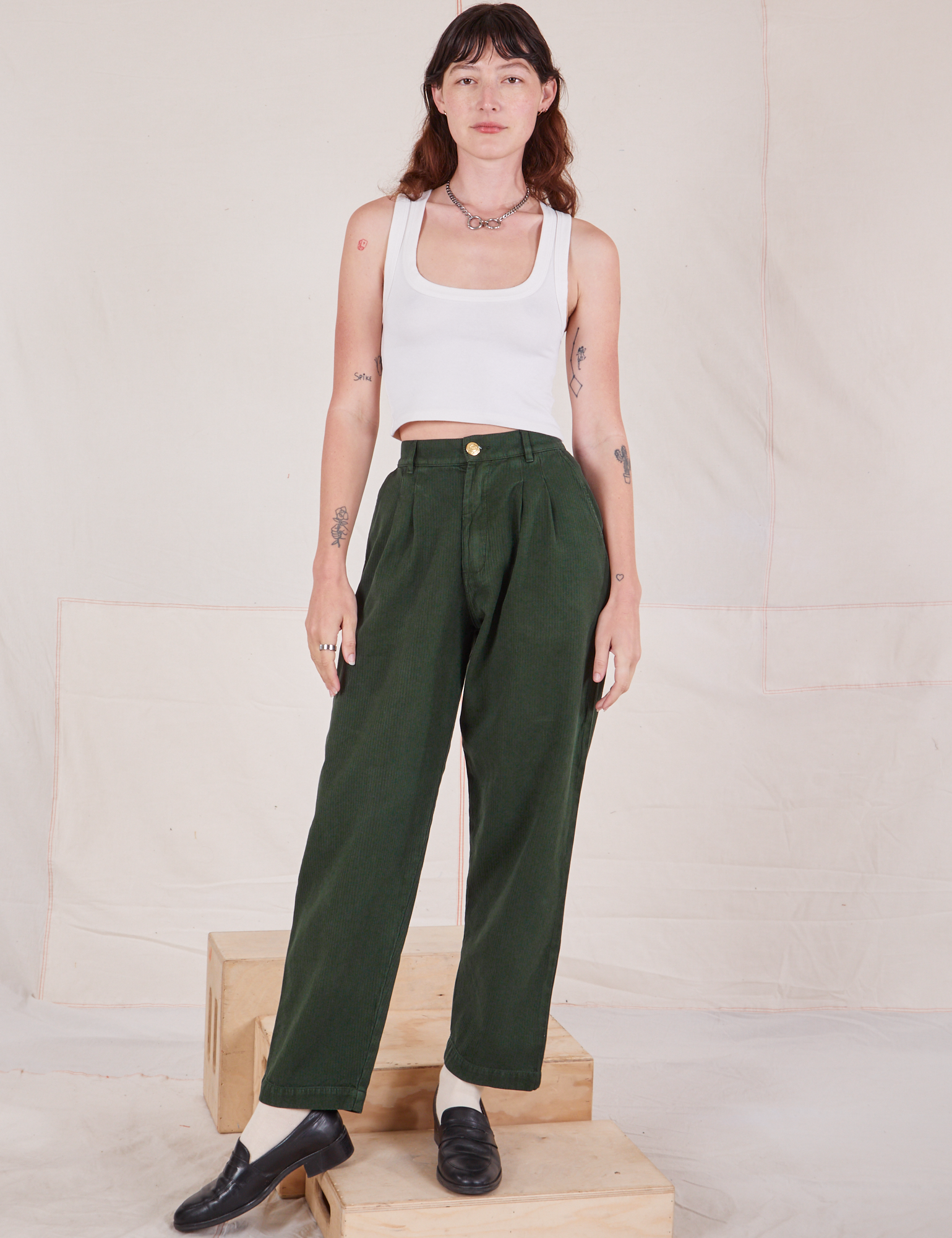 Alex is wearing Heritage Trousers in Swamp Green and a vintage off-white Cropped Tank Top