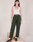 Alex is wearing Heritage Trousers in Swamp Green and Cropped Tank Top in vintage tee off-white