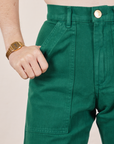 Front pocket close up of Work Pants in Hunter Green. Hana has her hand in the pocket
