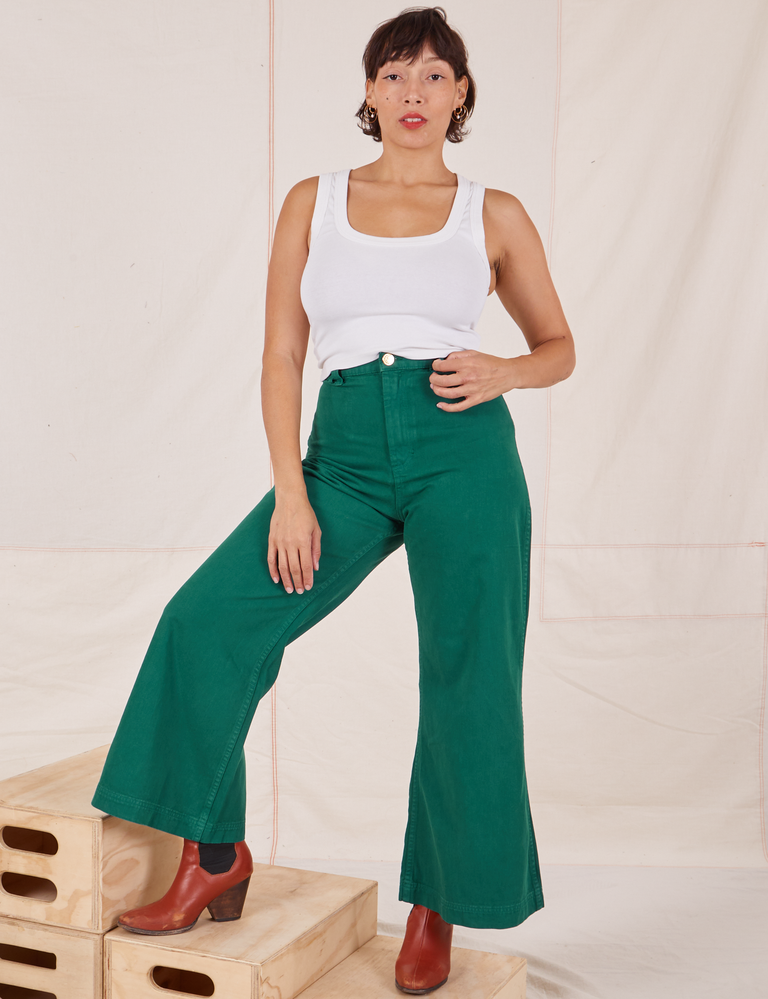Tiara is 5&#39;4&quot; and wearing XS Bell Bottoms in Hunter Green paired with Tank Top in vintage tee off-white