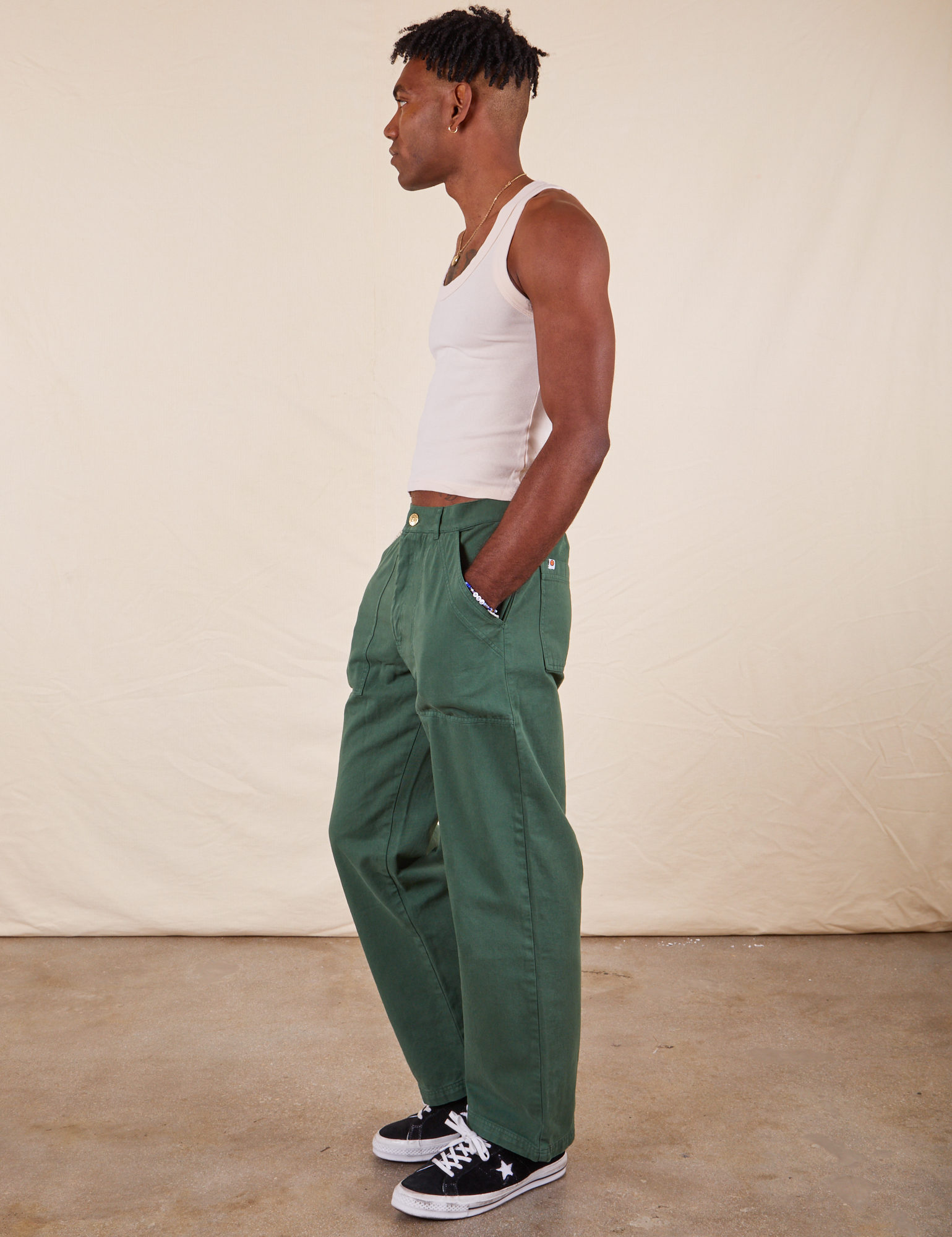 Jerrod is 6&#39;3&quot; and wearing Long S Work Pants in Dark Emerald Green paired with vintage off-white Tank Top