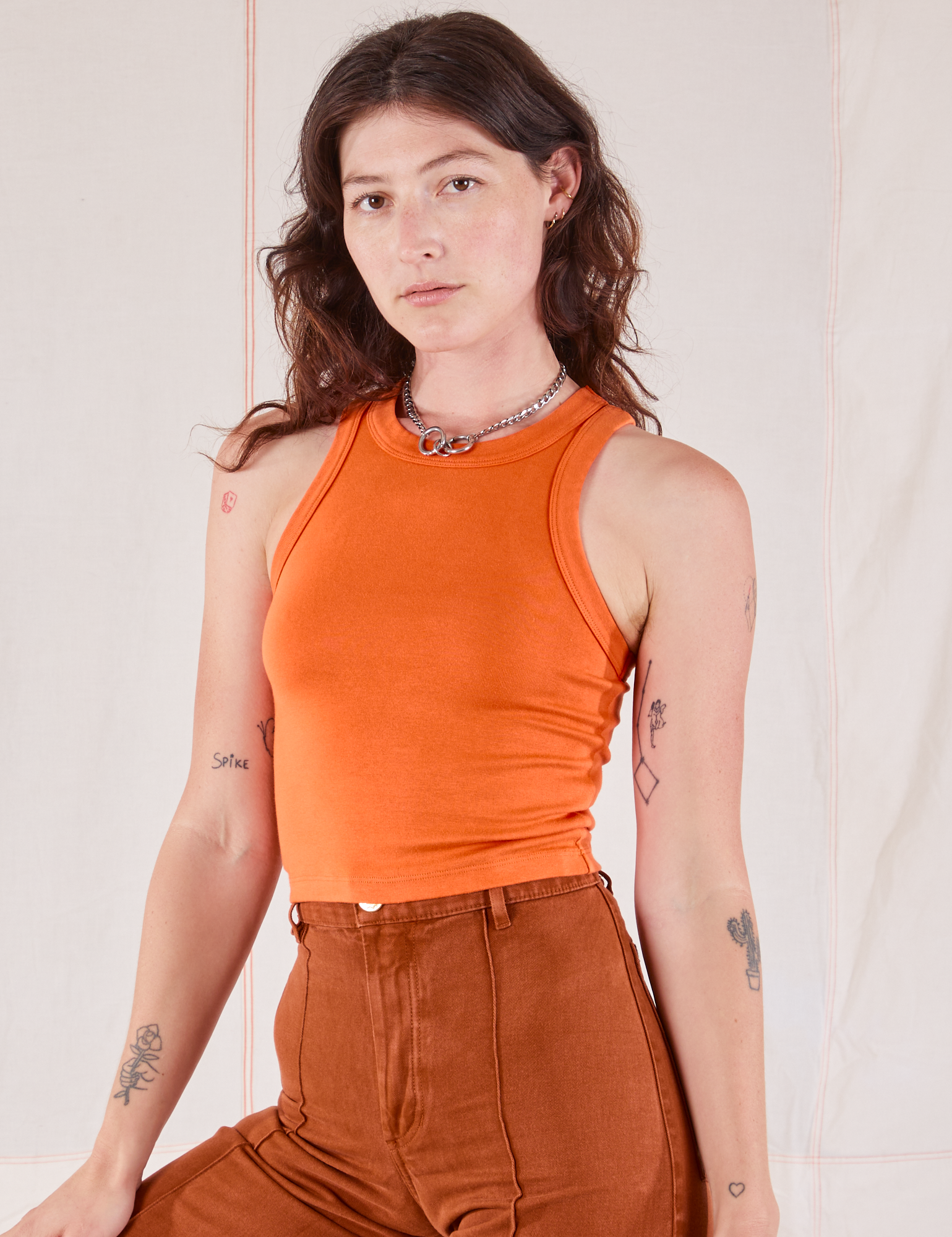 Alex is 5’8” and wearing P Racerback Tank in Sunset Orange