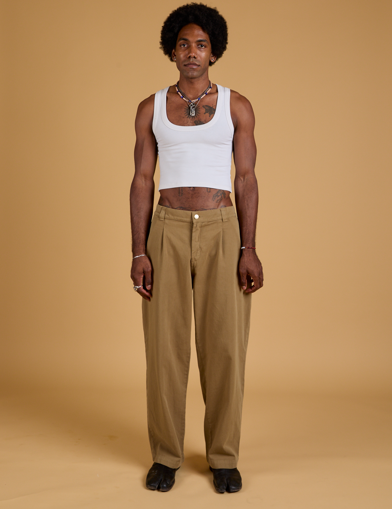 Jerrod is wearing Baggy Mid-Rise Trousers in Desert Brown and vintage tee white Cropped Tank