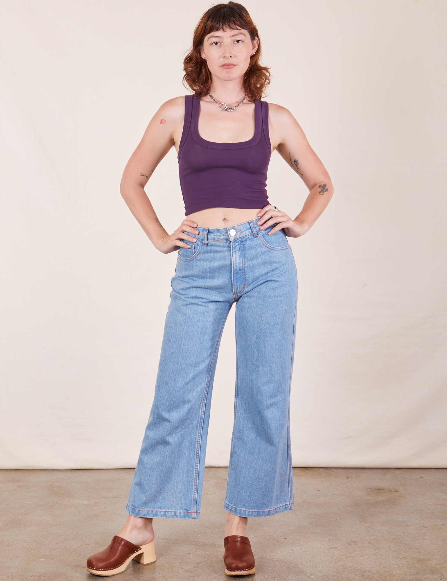 Alex is wearing Cropped Tank Top in Nebula Purple and light wash Sailor Jeans