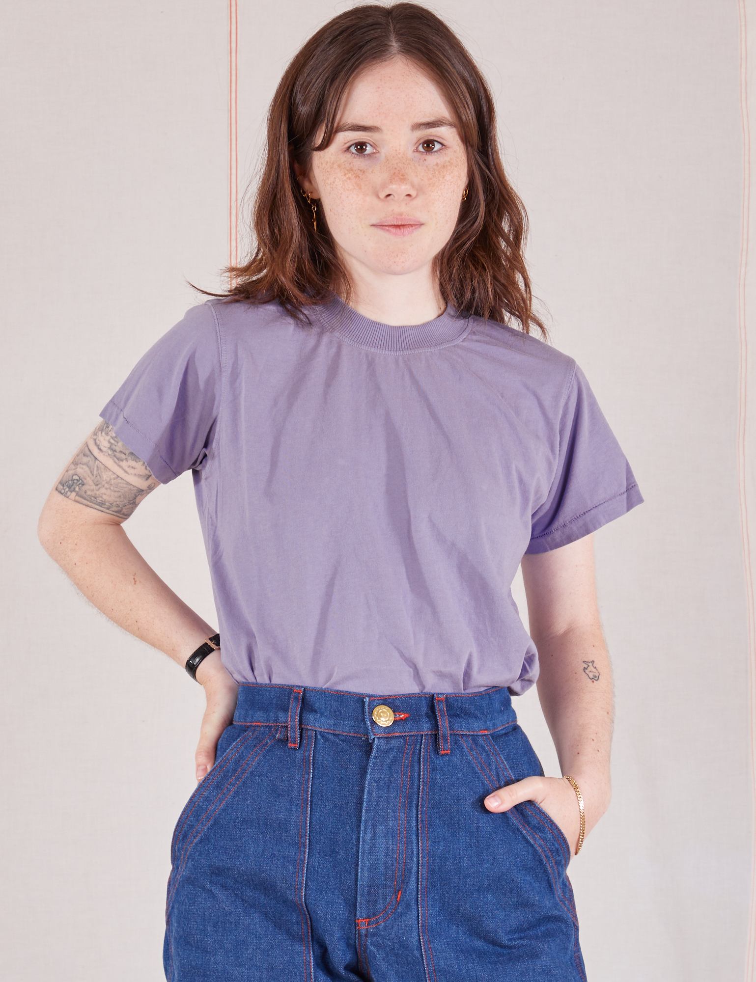 Hana is 5&#39;3&quot; and wearing P Organic Vintage Tee in Faded Grape tucked into dark wash Carpenter Jeans
