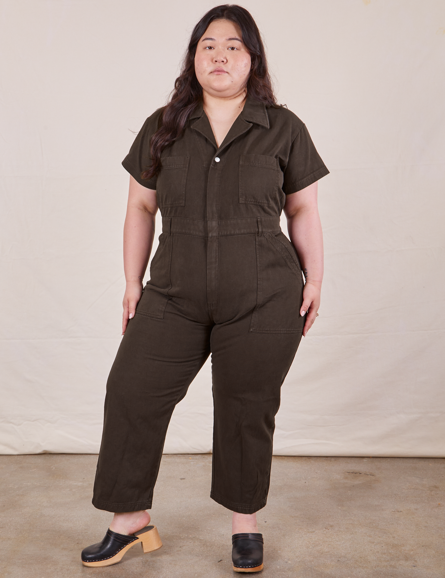 Ashley is 5’7” and wearing 1XL Petite Short Sleeve Jumpsuit in Espresso Brown