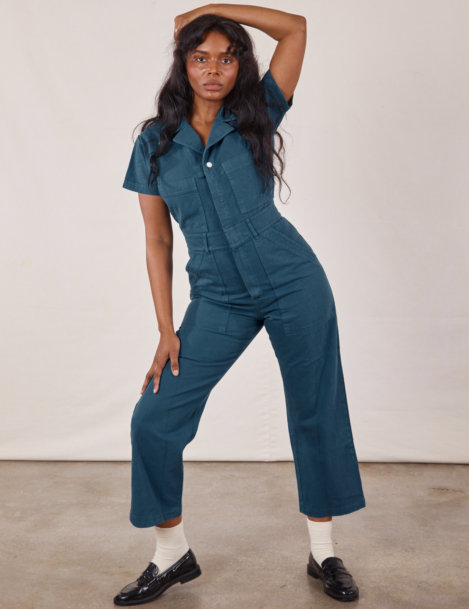 Kandia is wearing Petite Short Sleeve Jumpsuit in Lagoon
