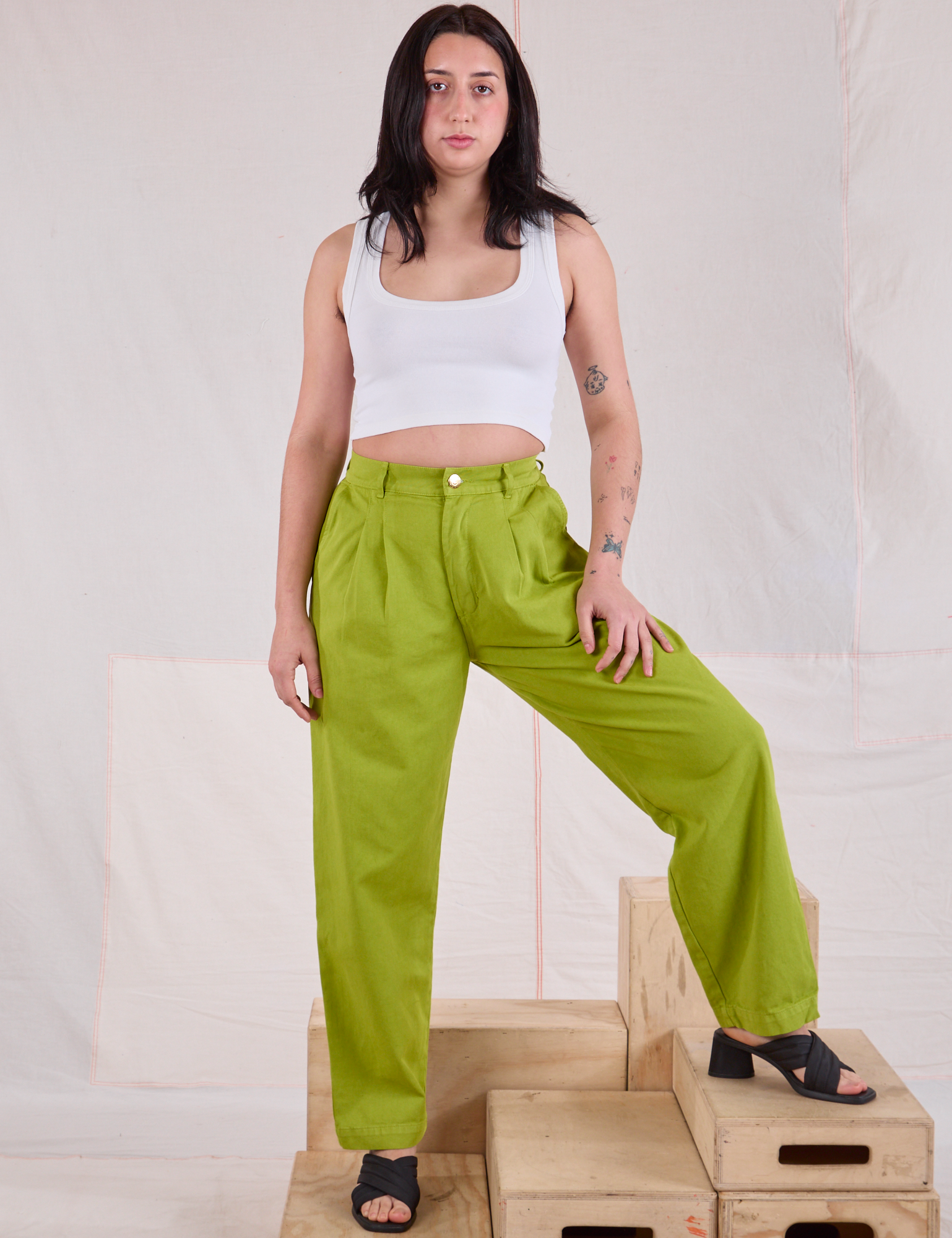 Betty is wearing Heavyweight Trousers in Gross Green and Cropped Tank in vintage tee off-white